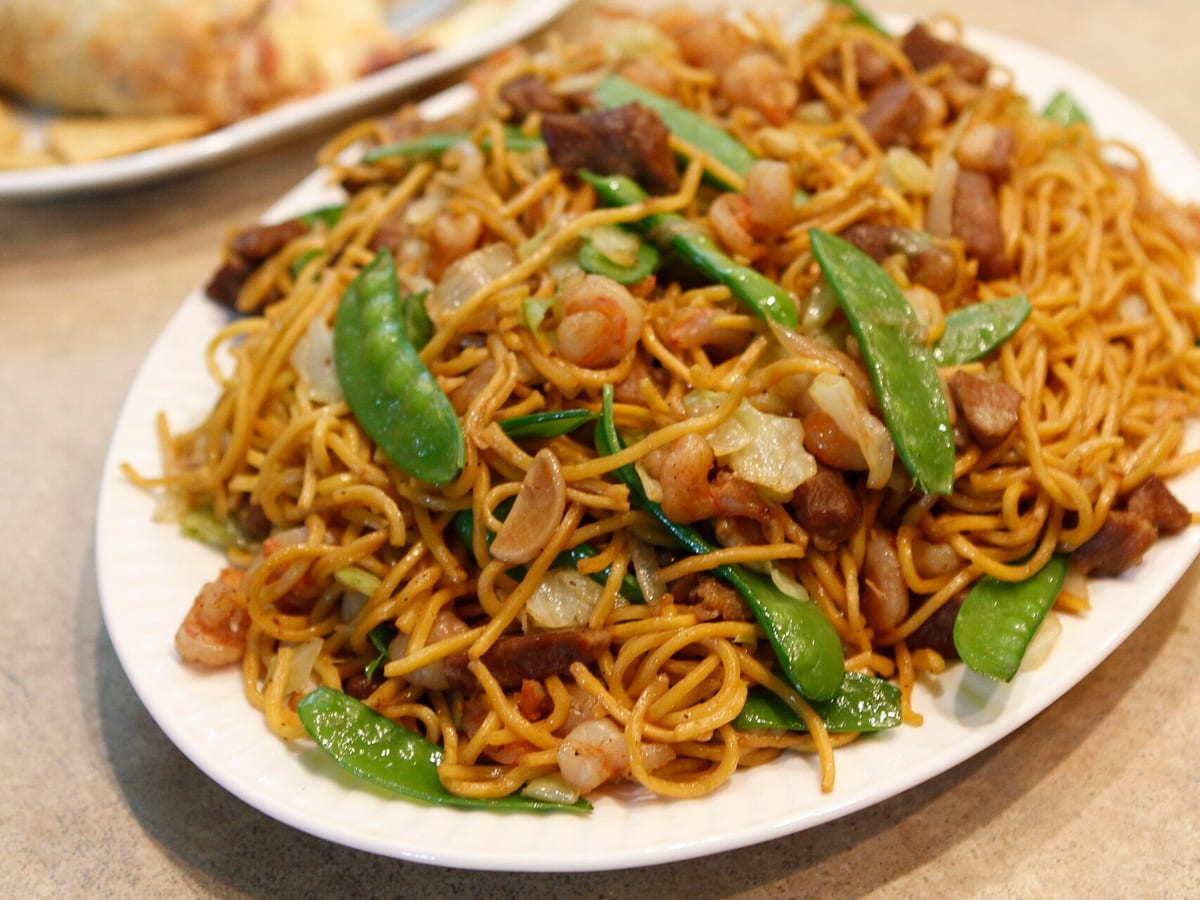 Platter of stir-fried pancit canton noodles with shrimp, pork and snow peas